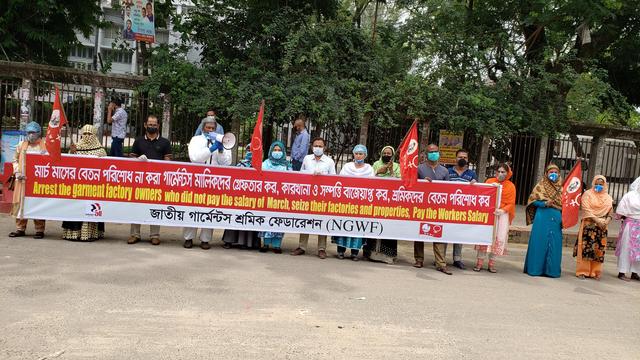 NGWF garment workers union members and officers wearing PPE (Covid virus safety masks) one speaks with a megaphone others are holding wide banner
Text
Arrest the garment factory owners who did not pay the salary of March, seize their factories and properties. Pay the workers Salary.
