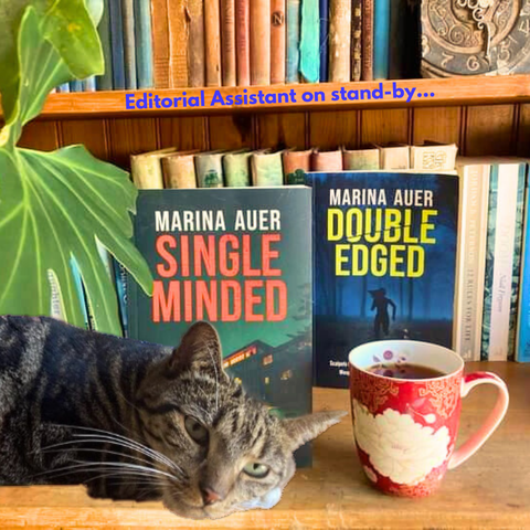 photo of 'Single Minded' and 'Double Edged' on bookshelf, with mug and cat; caption reads 'Editorial Assistant on stand-by...'