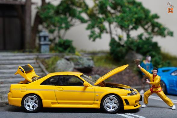 A guy in yellow suit and Nissan Skyline GT-R (R33) Nismo 400R Yellow by Pop Race in 1:64 scale with 1:64 figures on AREA 164