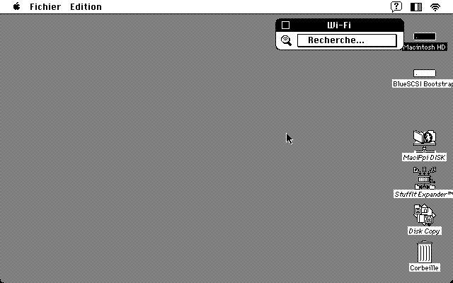 A screenshot of the Wi-Fi DA running on a PowerBook 145B in System 7 showing its dialog box with the French word "Recherche...".