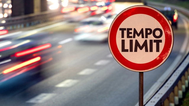 Foto: Verwischte Straßenszene mit Pseudeo-Verkehrszeichen "Tempolimit"