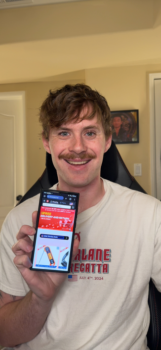 Ross sitting in a chair and holding a smartphone in his left hand. The phone screen displays a webpage from Innosearch.ai with a red and white theme, featuring a banner that says "FREE DELIVERY AND RETURN" and "Cyber Monday Deals." The page appears to be from a website called "innosearch.ai." 