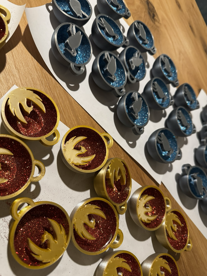 Half sphere shaped decorations containing a silhouette of Herons and Phoenix with a background of glitter.