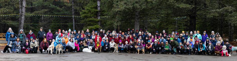 A large group of women, and some friendly doggos too, posing for the group picture at Freezing Woman 6.