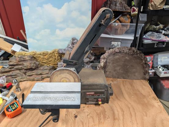 A craftsman bench sander, combo-belt-disk, sitting in my messy shop.