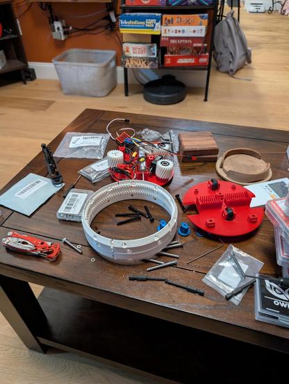 Messy coffee table covered in robot parts and hardware