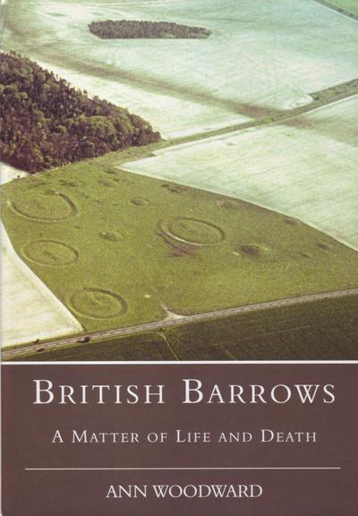 The front cover of the hardback edition of British Barrows: A Matter of Life and Death by Ann Woodward. Plain dark moss green with title in white and a large colour aerial photo of the Oakley Down Barrow Cemetery near Wimborne St Giles in Dorset.