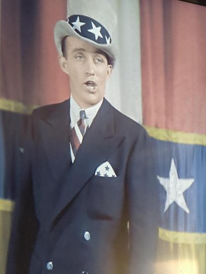 Bing Crosby in a starred hat in front of a starred curtain. HOLIDAY INN.