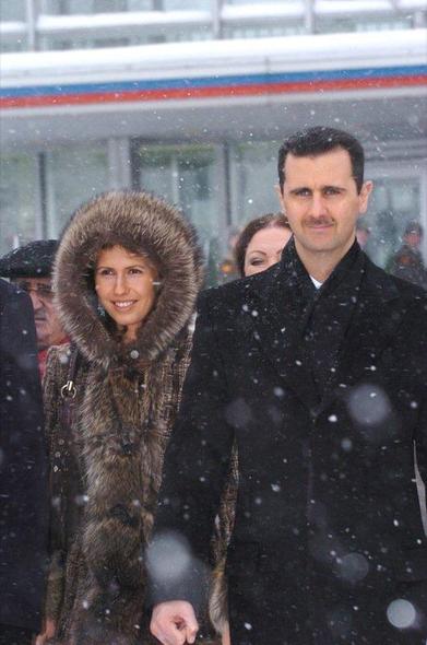 Bashar y Asma al Asad en Moscú, en enero de 2005. Ambos con abrigos y sonriendo. Se aprecia nieve cayendo.