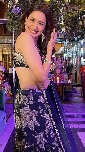 A black lehenga with a fish-cut design takes center stage as Pragya Jaiswal wows at a wedding event. This sophisticated ensemble exudes modern charm while staying rooted in tradition.