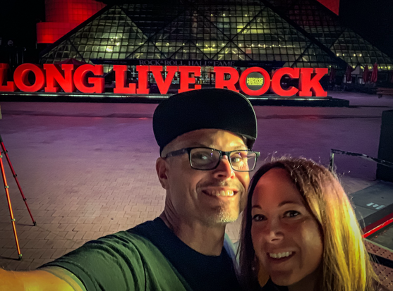 Man and woman in front of the rock and roll hall of fame in Cleveland Ohio. 
