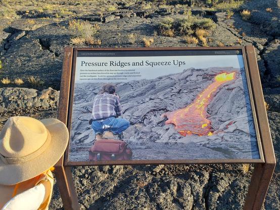 Ranger Sarah learns about Pressure Ridges. They form as the flow's crust is pushed upwards by the pressure of the moving lava beneath. The arched crust generally cracks open, and may allow molten lava to "squeeze up" to the surface like toothpaste out of a tube.
— at Craters of the Moon NPS.
