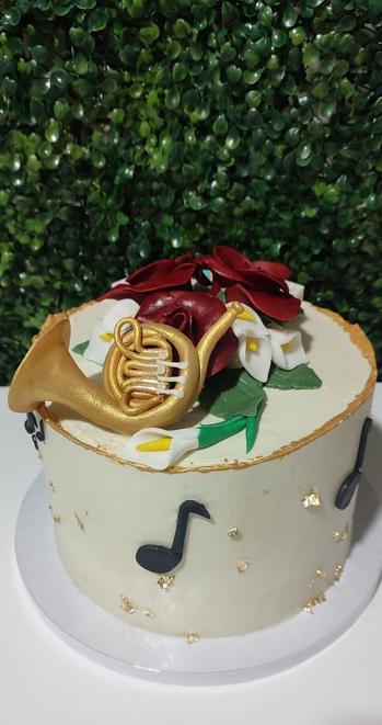 Parte trasera de la tarta donde se puede ver más flores, notas musicales y un instrumento musical