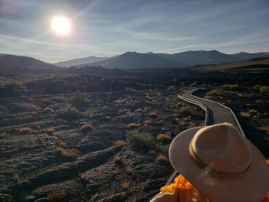 Ranger Sarah continues hiking through the Pahoehoe lava flow. he hot, fast-moving lava beneath pulls, pushes, and twists this cooler top layer into the weird ropes and coils. These ropes and coils can give you a hint to the direction the lava flowed.
— at Craters of the Moon NPS
