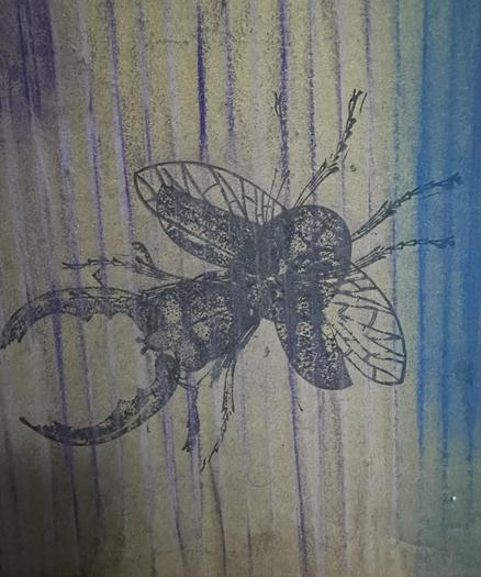 
Una imagen de un escarabajo grande, de color oscuro, impreso o pintado sobre un fondo texturizado de color beige y azul. El escarabajo tiene grandes mandíbulas y alas visibles. El fondo tiene líneas verticales en tonos beige y púrpura, creando un efecto de textura.  El estilo del dibujo es tosco, casi como una impresión.