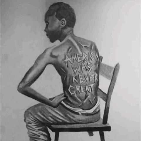 A black man, shirtless, sitting on a chair with scars on his back that read "America was never great."