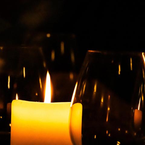 Candle sitting in between a couple of wine glasses.
