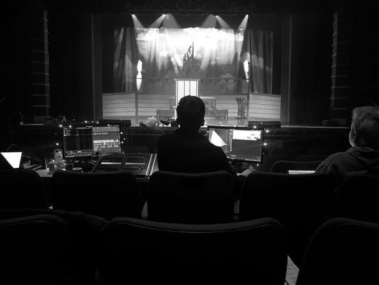 Black and white photo from behind the lighting desk at Theatr Colwyn during the Pinocchio Panto rehearsals.
