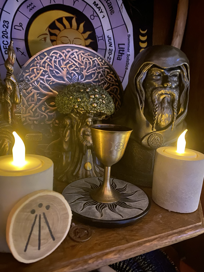 Pagan altar with Odin statuette and offering of red wine