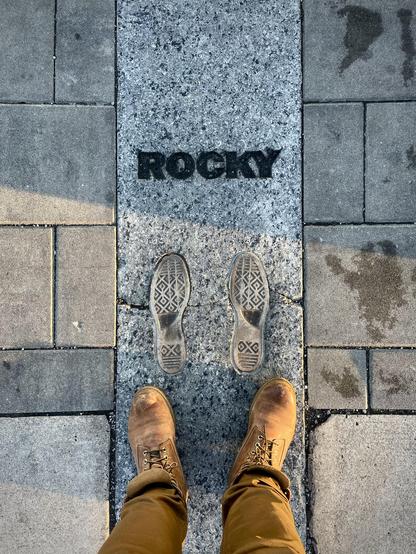 Rocky footprint on a granite block on the pavement, next to the statue, my feet right below, wearing timbs