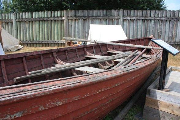 An old red-painted batteaux that was once on display at Fort Langley. This is a clinker built boat and it was rowed with long oars, as shown in the display.