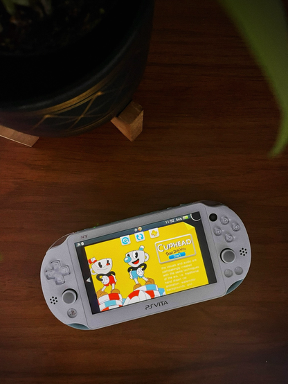 A gaming handheld on a wood grain tabletop. 