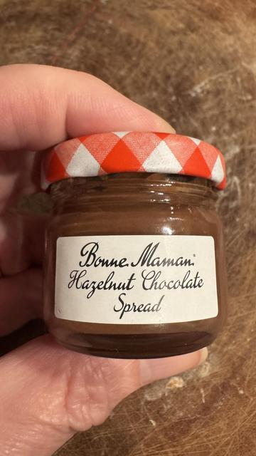A jar containing a brown substance. It has a red and white lid, with a cursive label describing its contents.