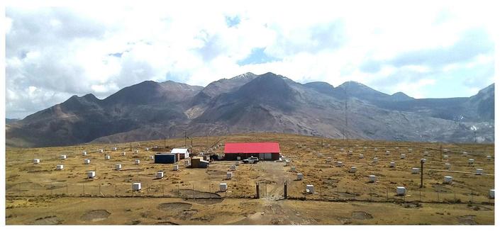 The photography of an air shower detector array located in a scenic landscape of the Andes mountains. The array consist of 97 units using plastic scintillators to detect the cascade of particles produced by high energy cosmic rays hitting the atmosphere.