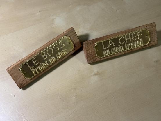 2 plaques de bureau fait en do it your self. Les plaques sont en laiton bien brillant chacun cloué avec clou laiton sur un morceau de vieux Chêne coupé avec un angle de 45 degrés et protègé à la cire d'abeille. Sur la plaque pour femme on peu lire "La chef, en plein travail" et sur celle pour homme"Le boss, projet en cour"