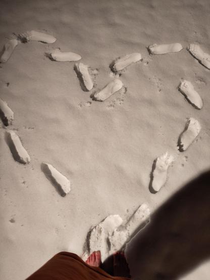 foot steps in snow in heart shape