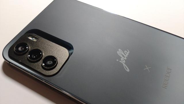 The back of the phone showing the camera bump. The back is a black/grey colour with "Jolla × Reeder" etched on the back.