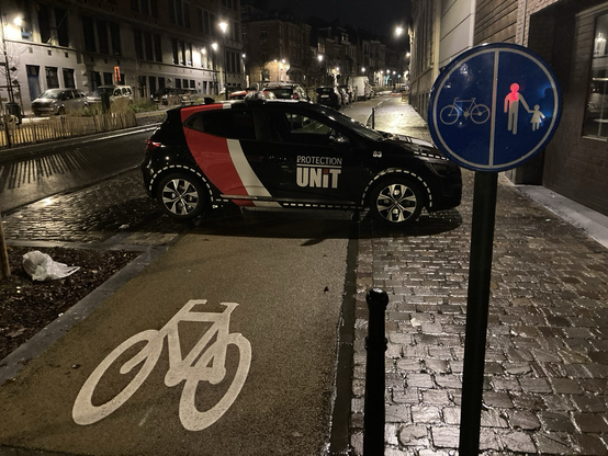 Une voiture marquée „protection unit“ bloque la piste cyclable