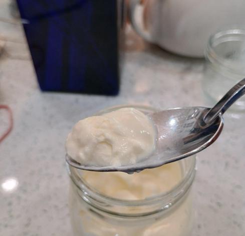 A thick yoghurt-like glob shown on a spoon, illustrates the thickness of the creme fraiche.