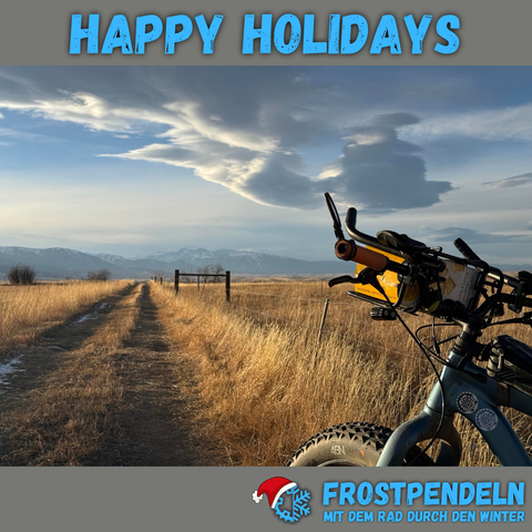 Fatbike auf einem Feldweg in Montana. Bildüberschrift: "Happy Holidays". Unten das Frostpendeln-Logo.