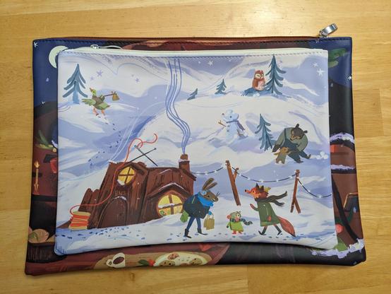 A stack of two project bags. The top one shows fox, rabbit, mole, and a few other woodland friends outside in the snow.