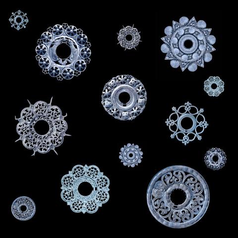 Dargestellt sind 3D-Rekonstruktionen mehrerer runder Gewandspangen, deren Form und Arrangement an Schneeflocken erinnert.