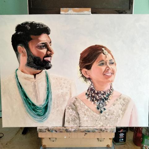 Bearded dark-skinned handsome groom and his beautiful light-skinned petit bride on his left both looking happy, gazing at a distance towards their left.
