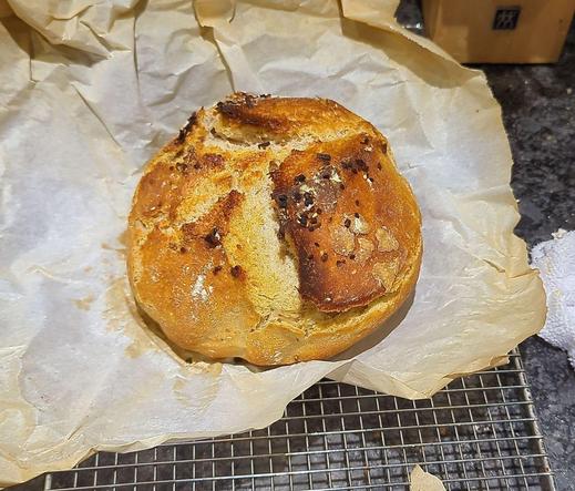 Round sourdough loaf fresh out of the oven on wax paper