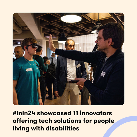 A demonstration at the #InIn24 event where a person wearing Envision Glasses interacts with a presenter. Several attendees observe in the background. The text reads '#InIn24 showcased 11 innovators offering tech solutions for people living with disabilities