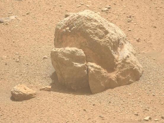 Crop of the linked photo, a broken rock resembling a head popping out of the regolith.