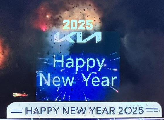 The sign in Times Square saying Happy New Year in a totally bland sand serif typeface. 