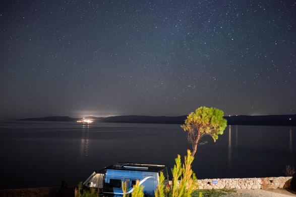 Nachtaufnahme, im Hintergrund Brac, im Vordergrund eine Pinie und Teile des Campingplatz. Man kann den Sternenhimmel erkennen.