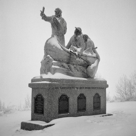 A black and white film photo. Frost covers the David Thompson monument in Lac La Biche, Alberta, Canada. Sunday, December 22, 2024.