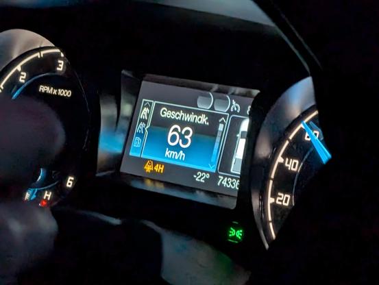 Foto der Anzeige im Auto. Wir fahren 63 km/h, Allrad ist zugeschaltet und die Temperaturanzeige sagt -22 Grad.