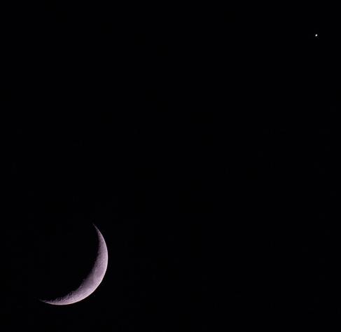 A photo of the crescent Moon in the bottom left corner of the frame, Venus in the top right corner.