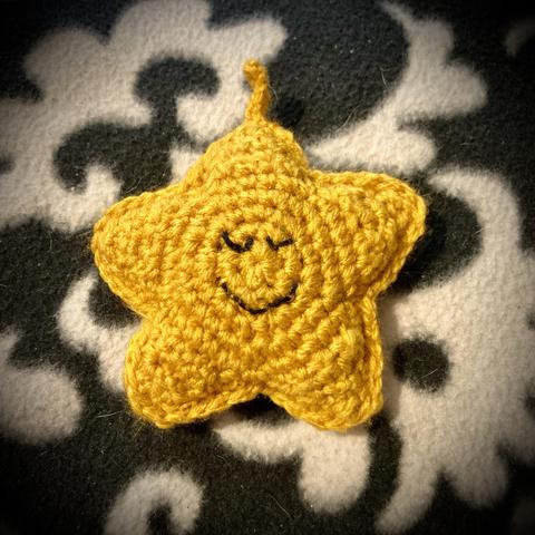 Front view of yellow crochet amigurumi starfish.