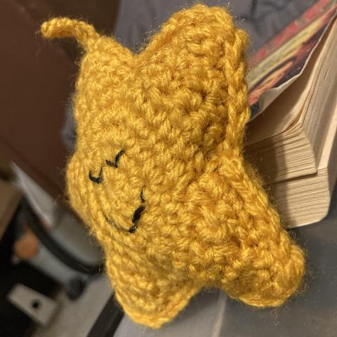 Side view of yellow crochet amigurumi starfish.
