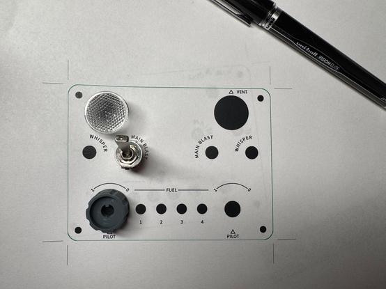 A printout of the test faceplate layout with a switch, knob, and LED lens on top to check positioning.