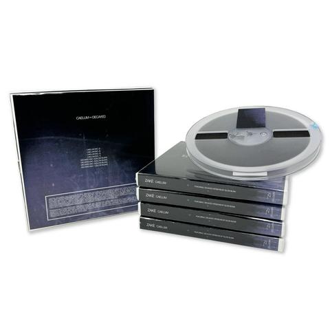 7" open reel tape spool atop four printed reel cases. An upright box container is to the left showing minimalistic artwork, white text on black background