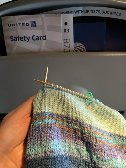A knitted hat in progress on a plane, taken by a passenger 
